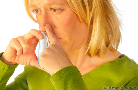 Woman using a nasal spray